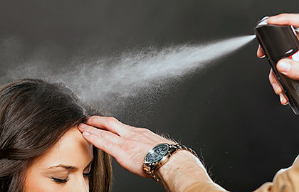 woman getting hair styled with hairspray